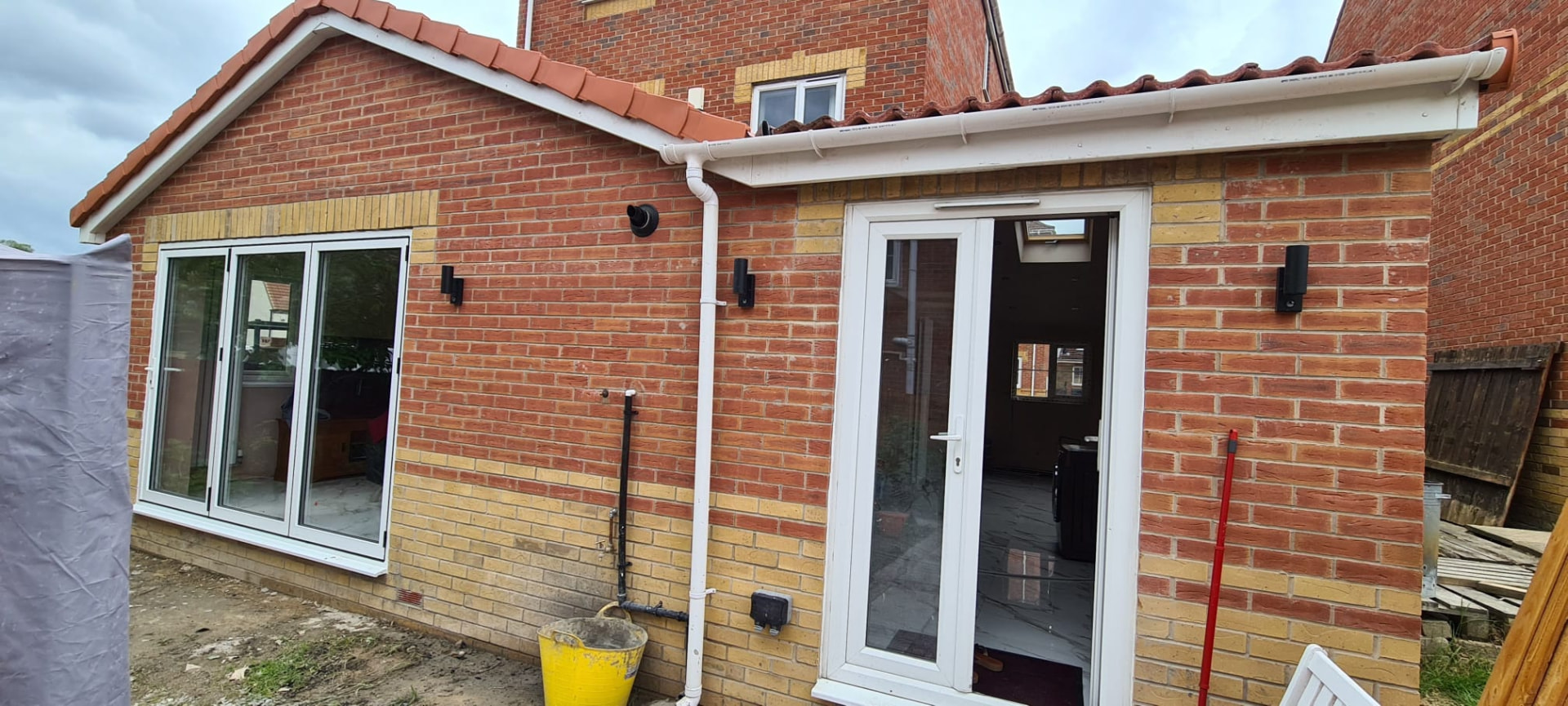 Red-brick rear extension brickwork and white patio doors, Leeds home extension