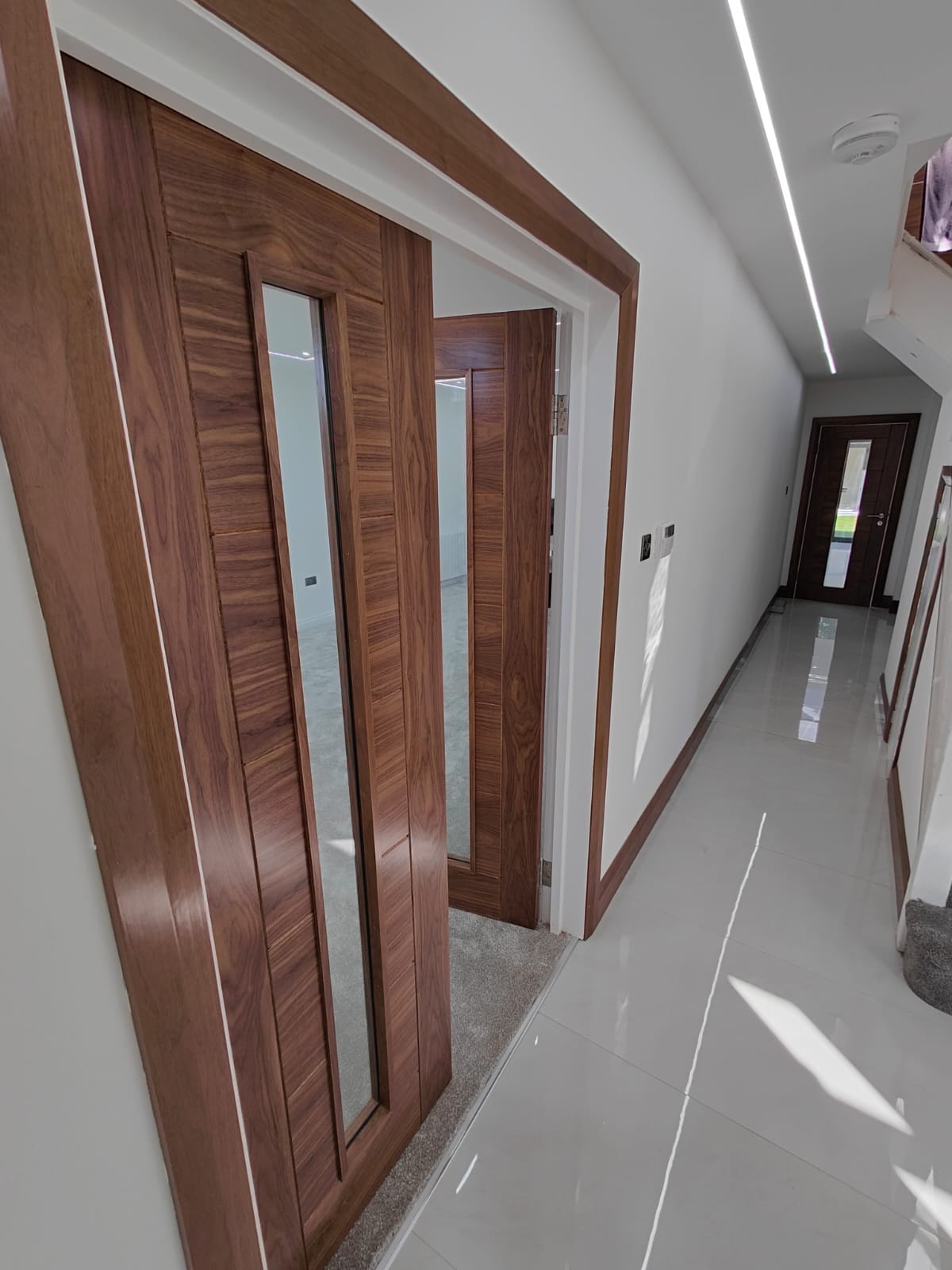 Premium walnut doors and polished tile hallway after plastering, Leeds