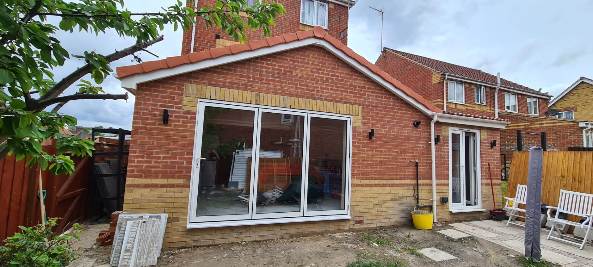 Finished red-brick rear extension with dark grey aluminium bi-fold doors, Leeds